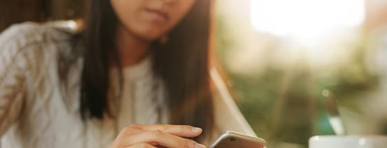 Mulher acessando pelo celular app da MetLife Brasil
